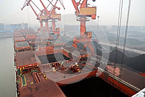 Cargo terminal for discharging coal cargos by shore cranes during foggy weather. Port Bayuquan,China. photo