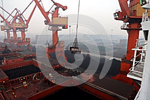 Cargo terminal for discharging coal cargos by shore cranes during foggy weather. Port Bayuquan,China. photo