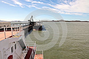 Cargo terminal for loading coal cargos by shore cranes. Port Gladstone, Australia. December, 2019.