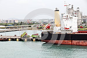 Cargo terminal for unloading steel plates from bulk carrier by ships cranes.  Port of Cigading. Indonesia, December, 2020.