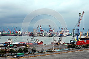 Cargo terminal for unloading steel plates from bulk carrier by ships cranes. View of the pier, cranes and various equipment. Port