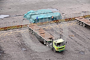 Cargo terminal for unloading steel plates from bulk carrier by ships cranes. View of the pier, cranes and various equipment. Port