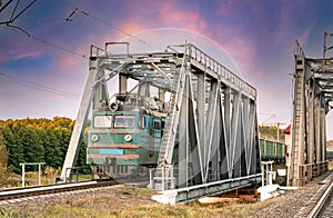 Cargo train on a metal bridge in motion