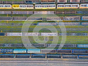 Cargo trains close-up. Aerial view of colorful freight trains on the railway station. Wagons with goods on railroad. Heavy