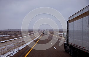 Cargo truck on Arizona desert highway on winter snow covers the highway