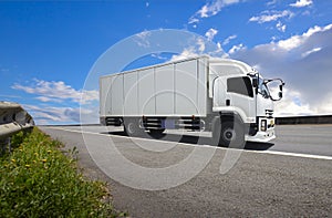 Cargo Truck Driving on the Road with a Blue Sky. Industry Road Freight Truck. Shipping Truck Logistics and Cargo Transport Concept