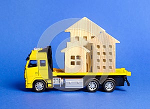 A cargo truck transports houses. Concept of transportation and cargo shipping, moving company. Construction of new houses