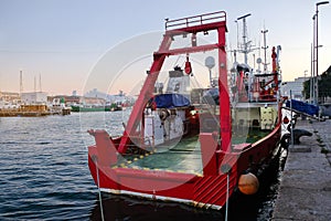 Cargo tug at the harbor pier. Sea port, boats and cranes