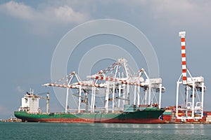 Cargo vessel and large crane operating at the seaport