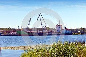 Cargoship unloading on the river Luga. Russia