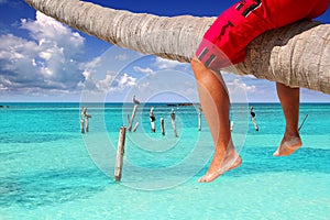 Caribbean inclined palm tree beach tourist legs