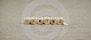caribe word built with wooden cubes and black letters on the floor and bottom of sand beach photo