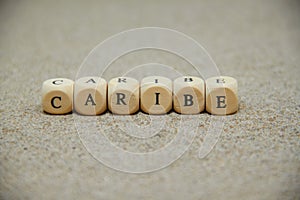 caribe word built with wooden cubes and black letters on the floor and bottom of sand beach photo