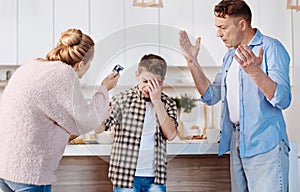 Carign parents punishing his son in the kitchen