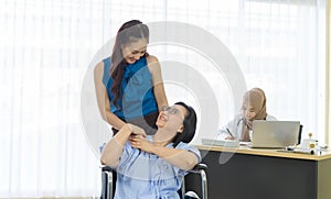 Caring adult daughter taking care her senior mother in wheelchair while visiting doctor