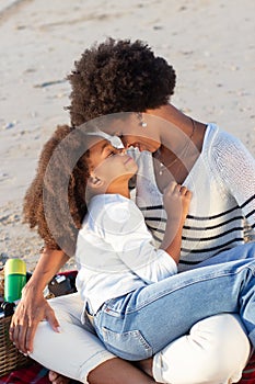 Caring African American family on picnic on beach