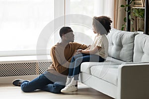 Caring African American father comforting adorable preschool daughter