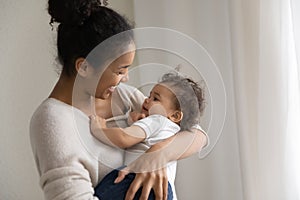 Caring african American mom lull small baby