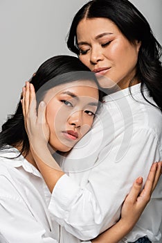 caring asian mother hugging young daughter