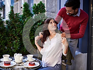 Caring bearded man putting jacket on his charming wife