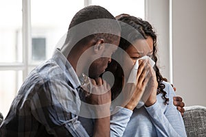 Caring black husband hug supporting sad crying wife