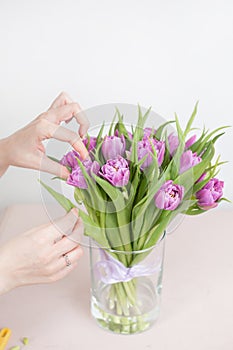 Caring for a bouquet of flowers, step by step. Cut the stems and put in a vase. Young woman holding a beautiful bunch of