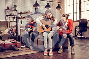 Caring boyfriend helping his beautiful girl playing the guitar