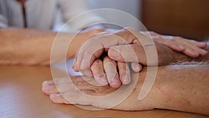 Caring caucasian grandma wife holding senior grandpa husband hand. old married grandparents couple together. elderly man