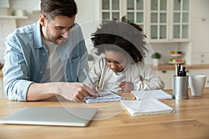 Caucasian stepfather helps with homework little mixed-race daughter