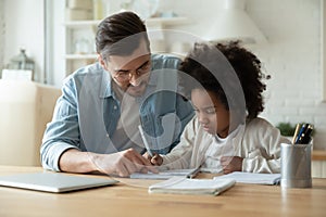 Caring dad help biracial daughter with homework at home