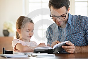 Caring dad teach small preschooler daughter reading