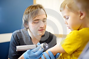 A caring doctor checks moles on the skin of a small child.