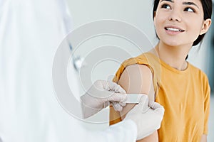 caring doctor in protective gloves to stick the injection to a woman covid