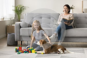 Caring dog owner grandma watching little kid from couch