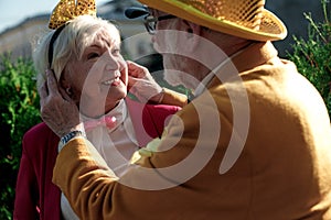 Caring elderly man with wife in funny clothes stock photo