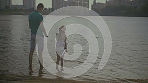 Caring father and cute daughter angling on river