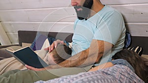 Caring father reading bedtime story to his children at home. Evening family reading. Kids listening dad, reading a