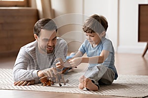 Caring father and small son play together at home