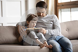 Caring father teach little son reading book
