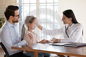 Caring female doctor cheer small girl child patient