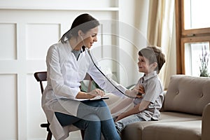 Caring female doctor listen to child heart at checkup