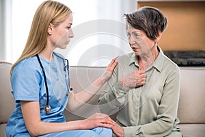 Caring female doctor supporting elderly patient in hospital