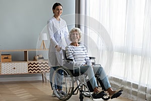 Caring female nurse support disabled senior woman patient