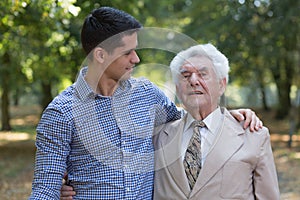 Caring grandson and his grandfather photo