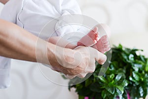 Caring hands of parents. Children`s feet in the hands of his father. father and her baby. The concept of a happy family. Beautifu