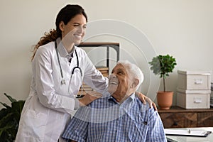 Caring happy nurse comfort old male patient in hospital