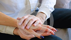 Caring husband holding his wife's hand shows sympathy and comfort.