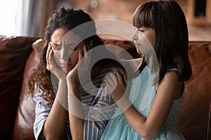 Caring little daughter comfort upset mom at home