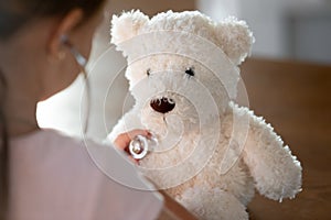 Caring little kid examine plush teddy bear