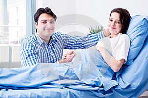 The caring loving husband visiting pregnant wife in hospital